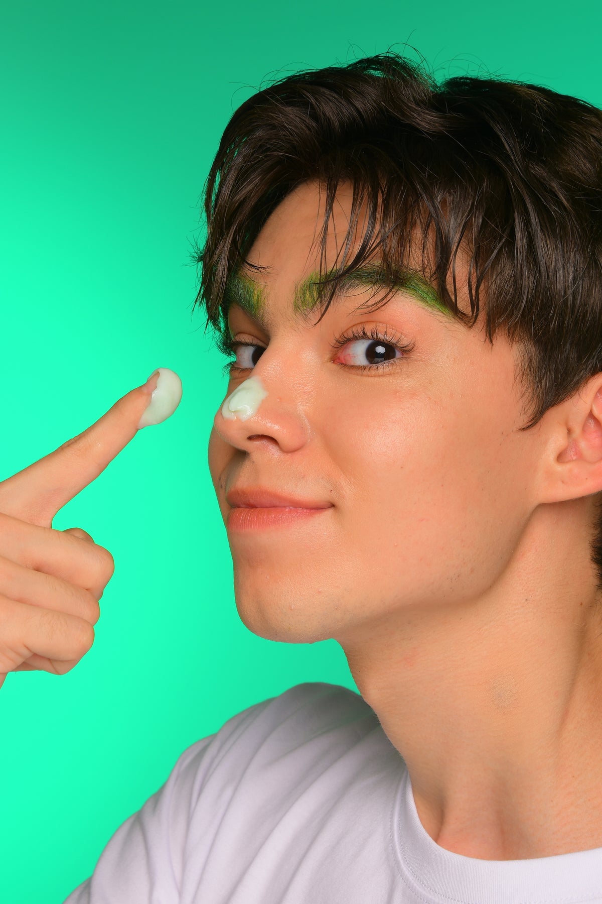 model applies tovegan green cream on his nose